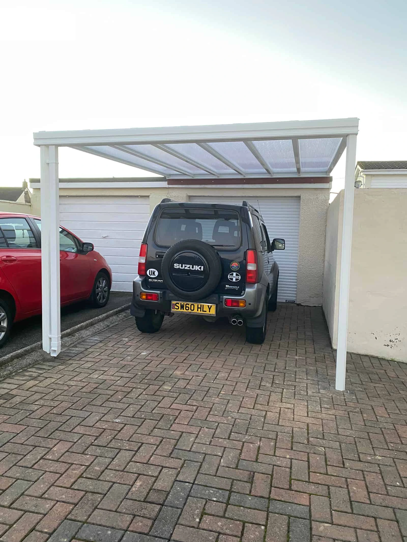 Harbour aluminium carport fitted between a house wall and fence