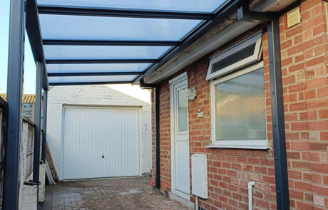 Harbour anthracite carport with polycarbonate roof on a brick side-passage driveway